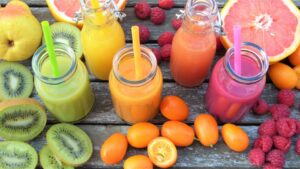 Quattro estratti di diversi colori in tavola, causa di danni da eccesso di fruttosio