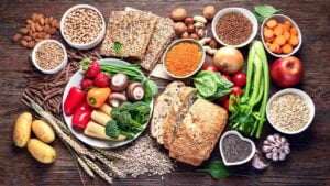 Tavola con molteplici fonti di fibre alimentari: cereali integrali, verdure, legumi, patate dolci