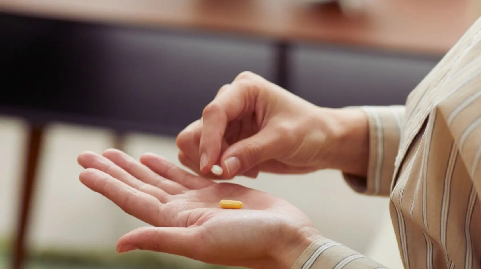 Mano che tiene una capsula e una compressa, simbolo dell’integrazione di vitamina B12