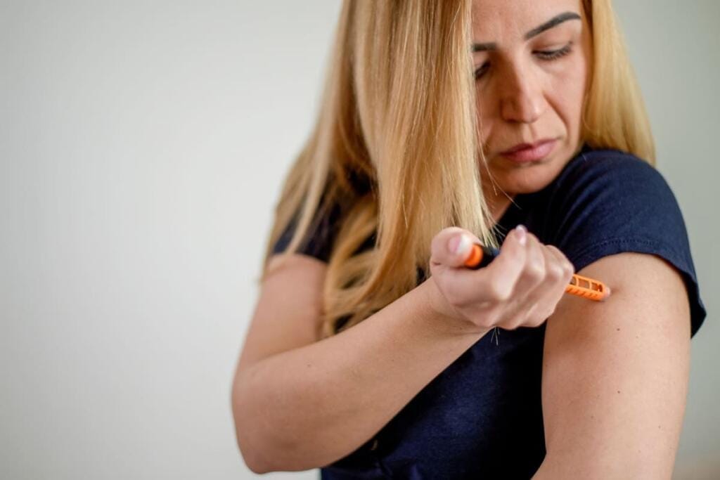 Donna che si inietta insulina nel braccio per regolare la glicemia e gestire il metabolismo del glucosio