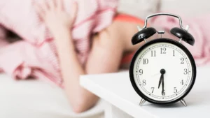 Sveglia e persona che non vuole alzarsi, rischio di alterare il ritmo circadiano