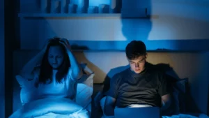 Coppia a letto con computer portatile acceso prima di dormire