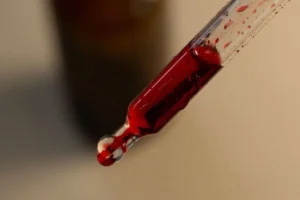 Contagocce con integratore liquido rosso in primo piano