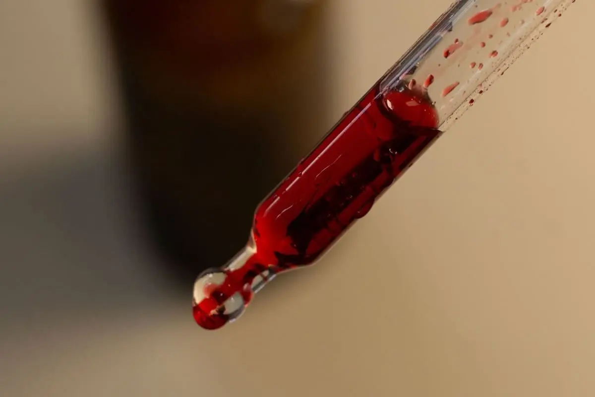 Contagocce con integratore liquido rosso in primo piano