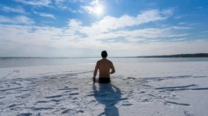 Uomo immerso nell’acqua ghiacciata, intento a praticare cold exposure, adattamento fisiologico al freddo
