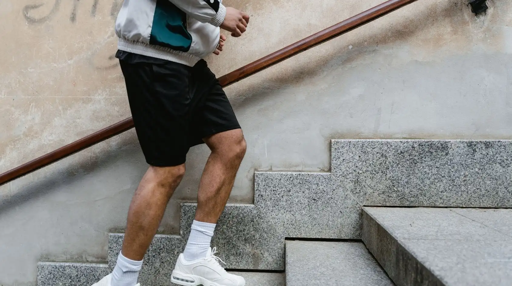 Uomo che sale le scale come micro-workout quotidiano per migliorare metabolismo e forma fisica