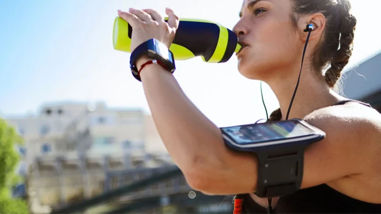 Atleta che beve acqua durante un allenamento estivo, concetto di idratazione e bilancio elettrolitico (sodio, magnesio e potassio nello sport)