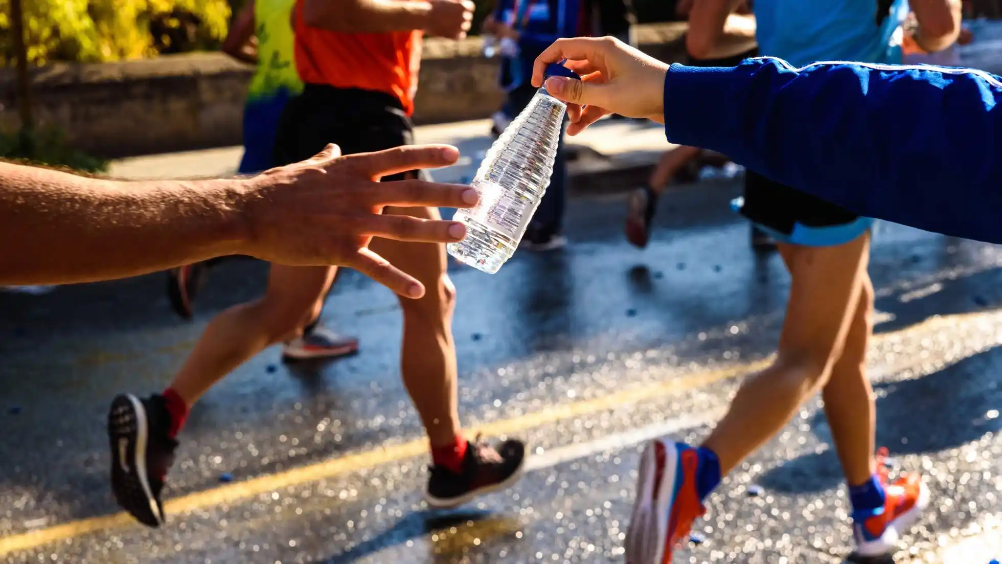 Atleta di endurance si idrata durante l’allenamento in ambiente caldo per reintegrare liquidi ed elettroliti