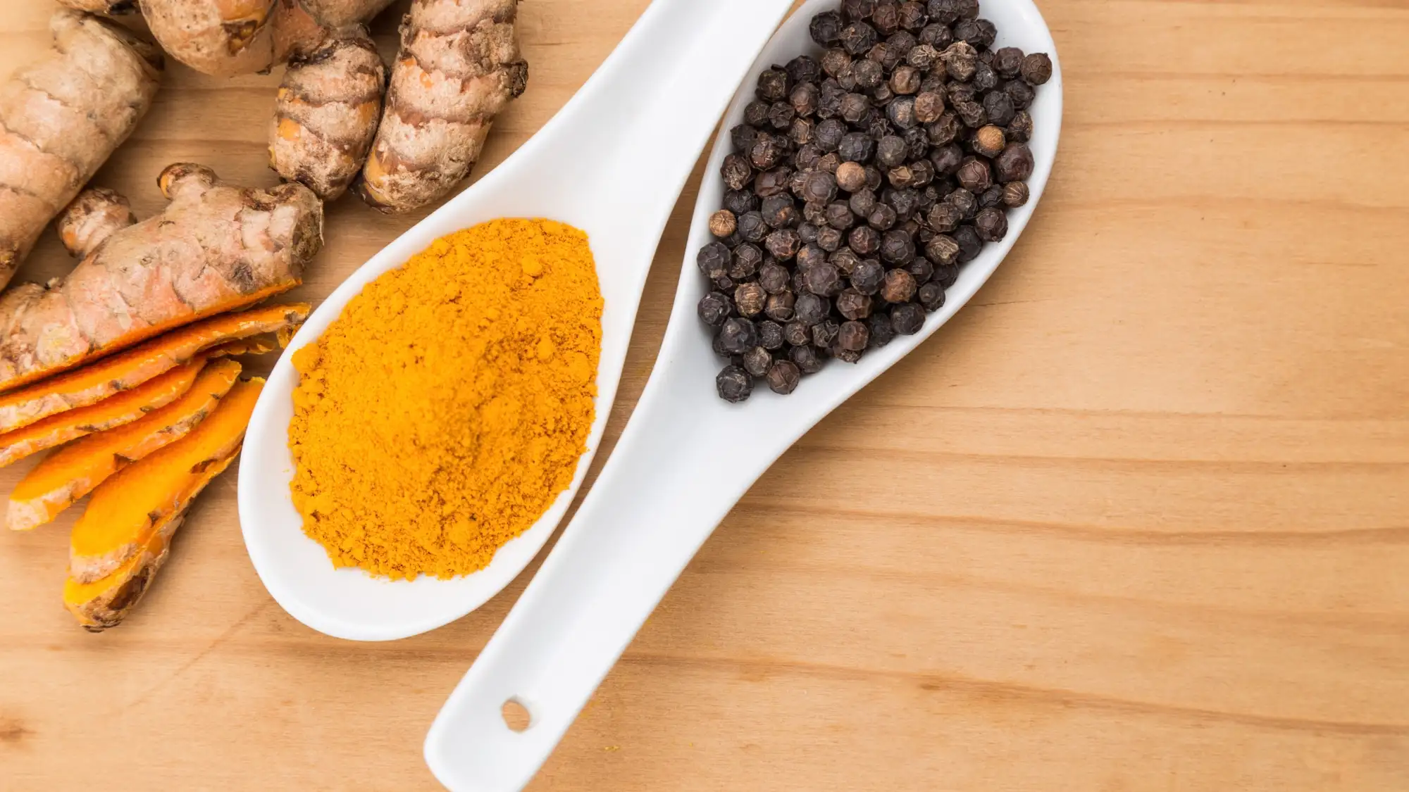 Curcuma in polvere, rizoma di curcuma e pepe nero in grani