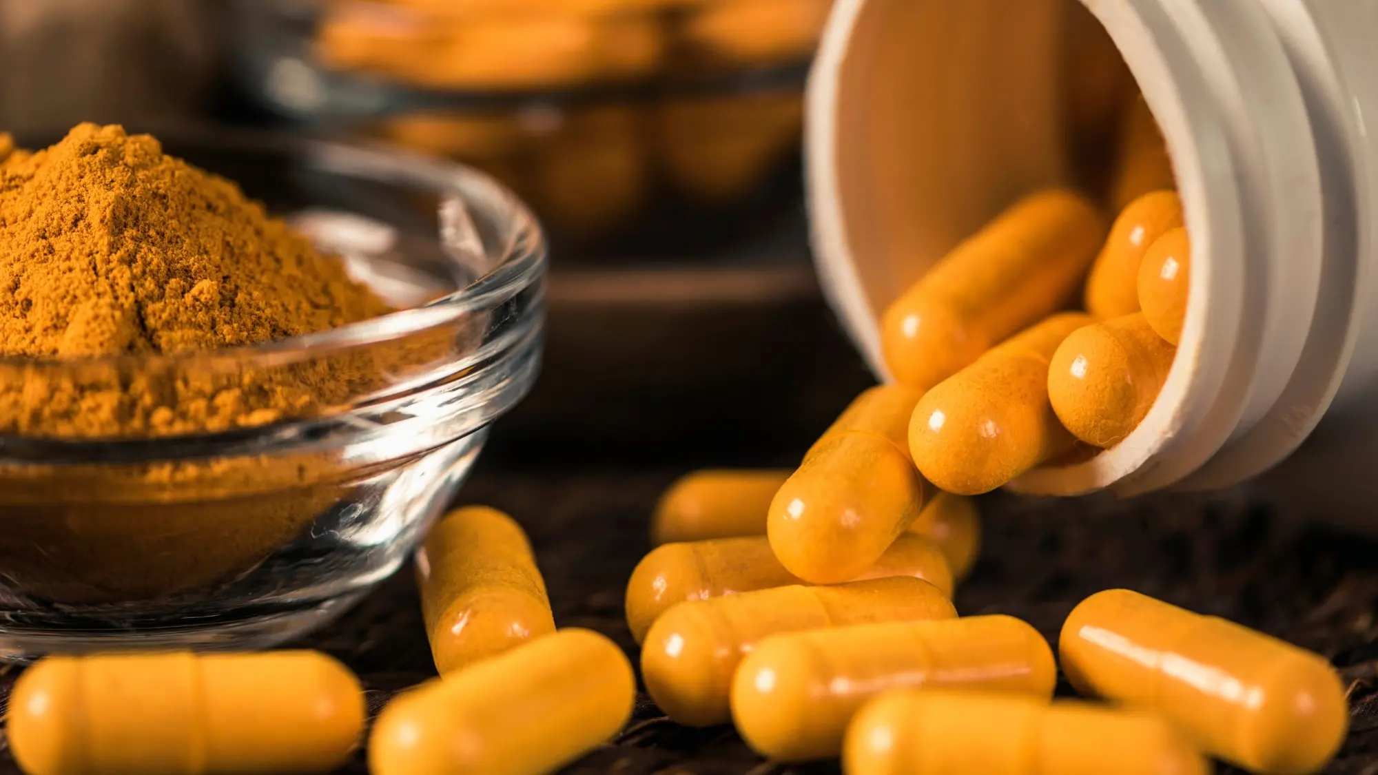 Curcuma in polvere accanto a capsule di integratore