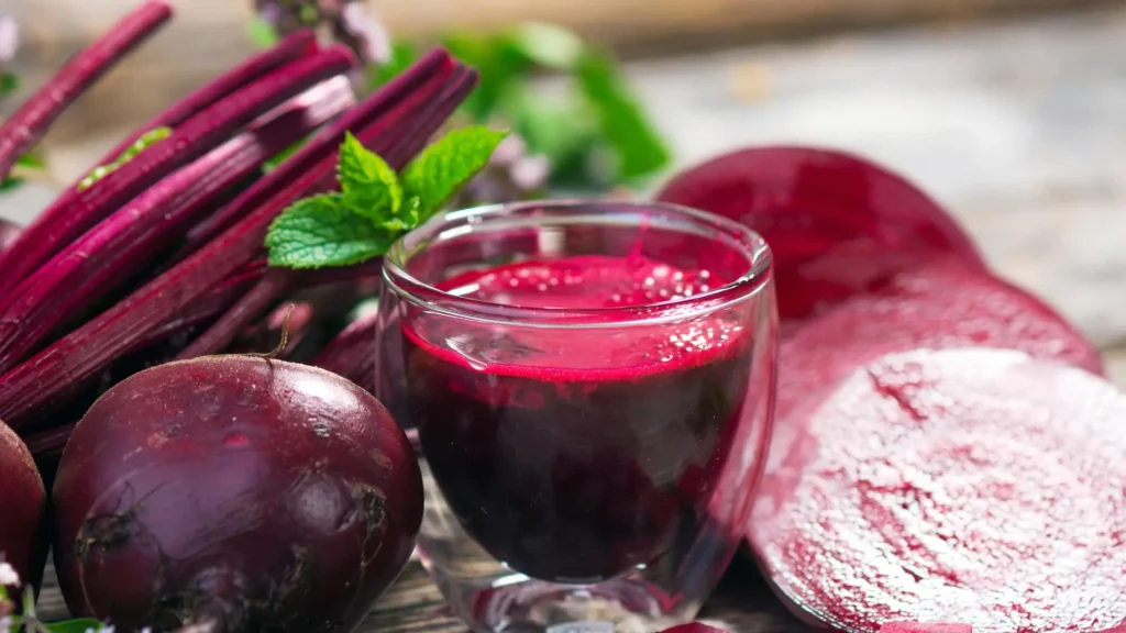 Succo di barbabietola rossa con barbabietole fresche sul tavolo